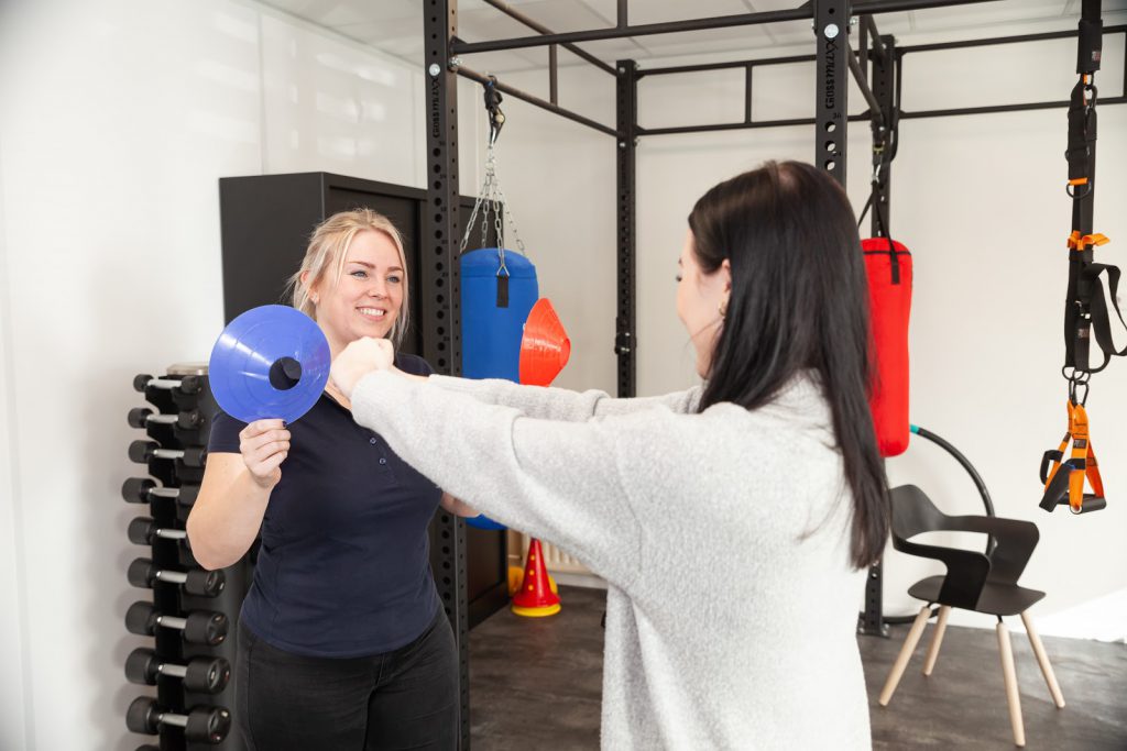 De fysiotherapeut helpt een vrouw met sportblessures