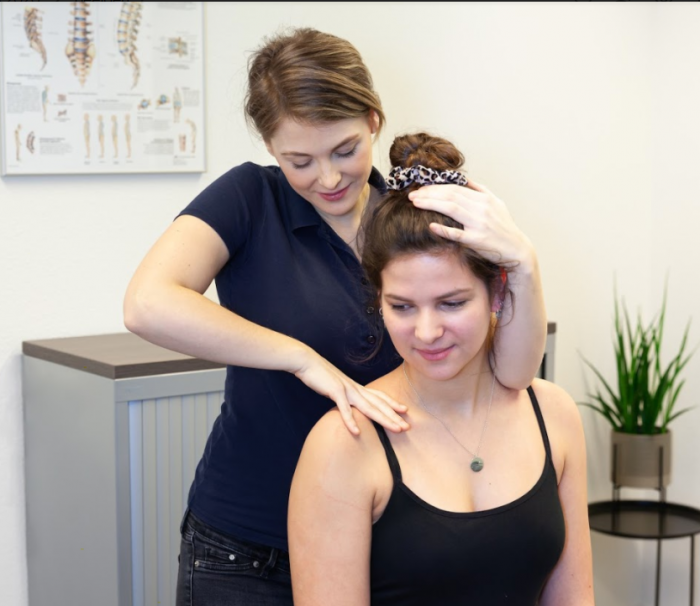 Stijve nek Roosendaal Fysiotherapeut helpt iemand met een stijve nek