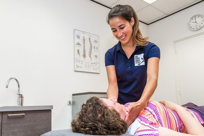 De fysiotherapeut helpt een vrouw met kaakklachten