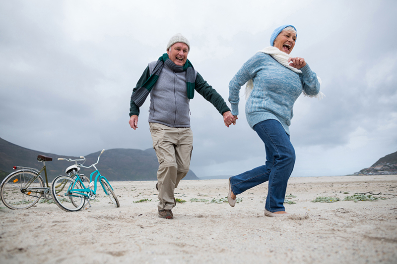2 oudere mensen rennen over het strand en blijven zo in beweging